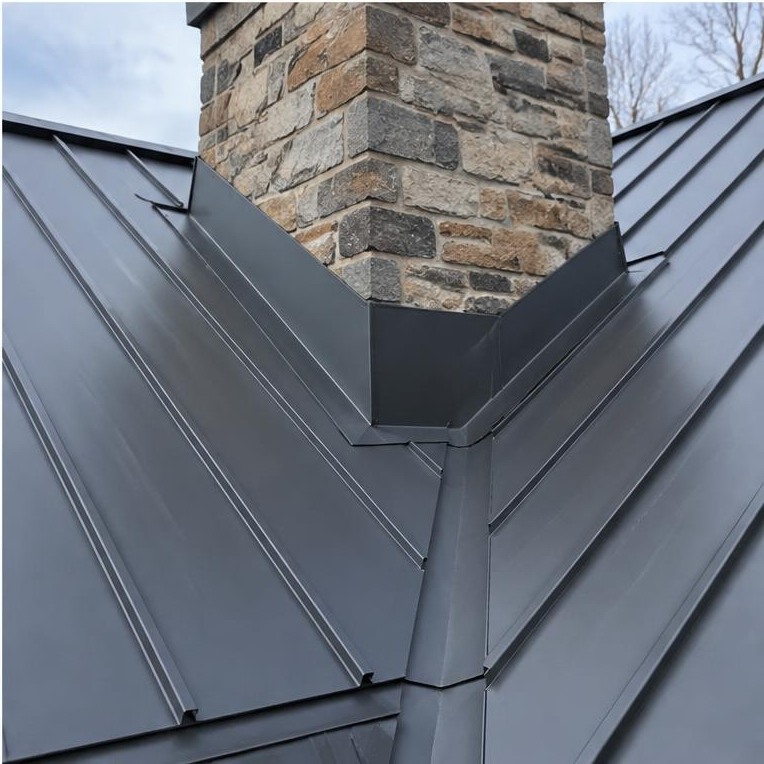 Custom metal roof flashing around a stone chimney